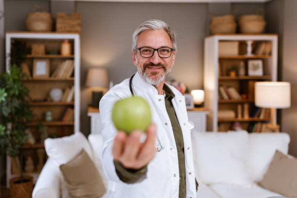 istock Handsome senior doctor is holding an apple 2150448583