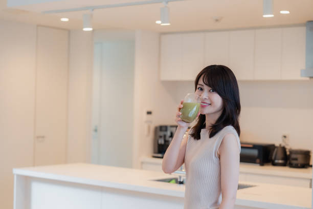 istock Young woman drinking a smoothie at home 2150451326