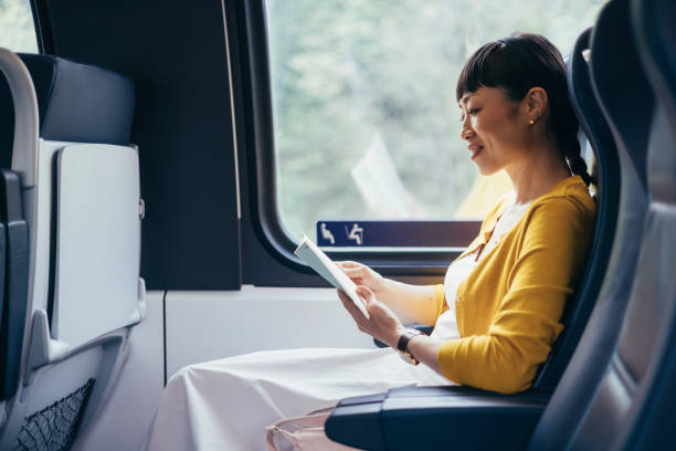 istock Woman Reading on a Peaceful Train Ride in Daylight 2150451570