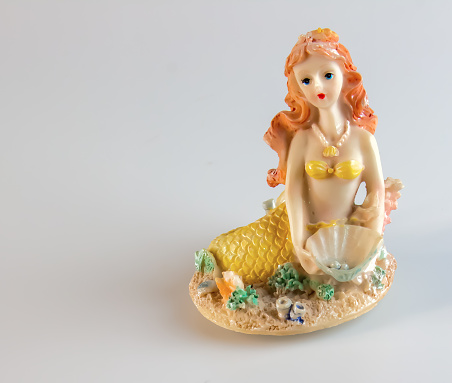 Mermaid figurine on a white background. Fairytale character. Toy mermaid. Feminine appearance.