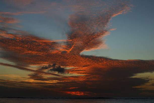 Albion, Mauritius - April 27, 2024: Vibrant colors during sunset at the Indian Ocean close the public beach of Albion in the West of Mauritius. Some clouds make the scenery more spectaculor.