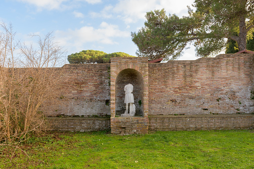 Statue in niche in courtyard in Ostia Antica. Ruins of ancient roman city and port. Rome, Latium, Italy