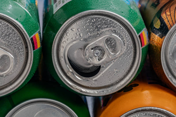 istock metal beer cans in row in foreground,water 2150456389