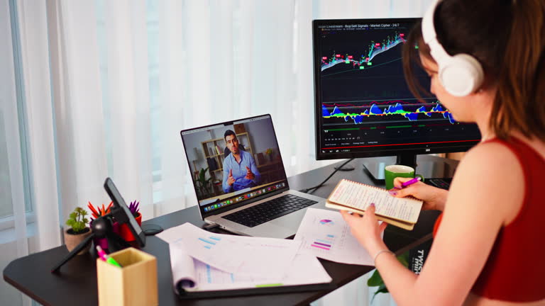 Young Business Woman working at an Ergonomic standing desk while walking on a treadmill, online meeting while checking Bitcoin or stock market price chart on a digital exchange,