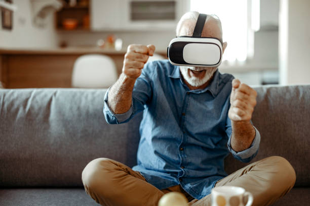 istock Happy Senior Man With Vr Headset Playing Video Game at Home 2150457214