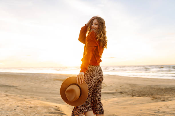 istock Beautiful woman walking at a beach at sunset. 2150458203
