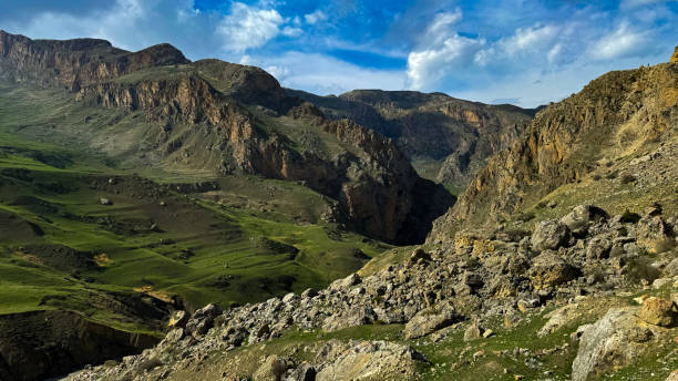 istock Mountain landscape with green valleys, rugged cliffs under blue sky with clouds. For advertising banner or post card of outdoor adventure and travel themes. 2150459008
