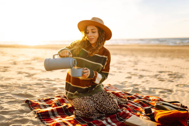 istock woman sits at picnic on the beach 2150459032