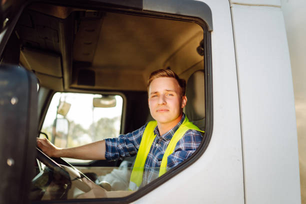 istock Handsome driver at the wheel of a truck at work. 2150459217