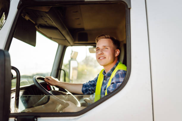 istock Handsome driver at the wheel of a truck at work. 2150459218