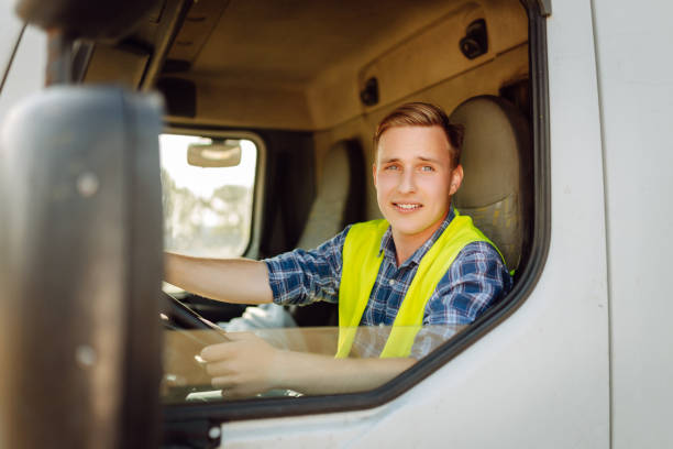 istock Handsome driver at the wheel of a truck at work. 2150459224