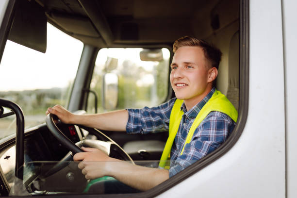 istock Handsome driver at the wheel of a truck at work. 2150459228