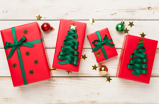 Creative handmade christmas gift boxes with decor on wooden background, top view