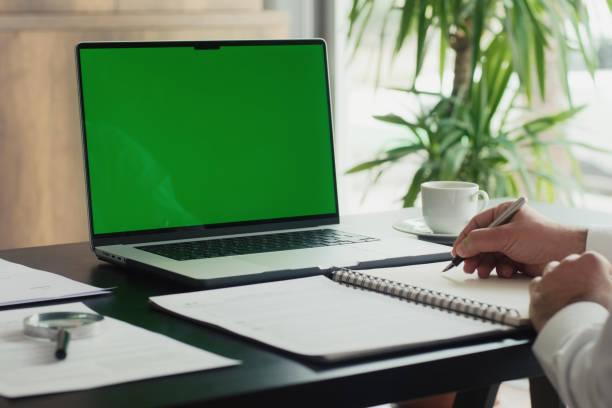 istock Businessman Using Laptop Computer With A Chroma Key Green Screen In The Office 2150459433