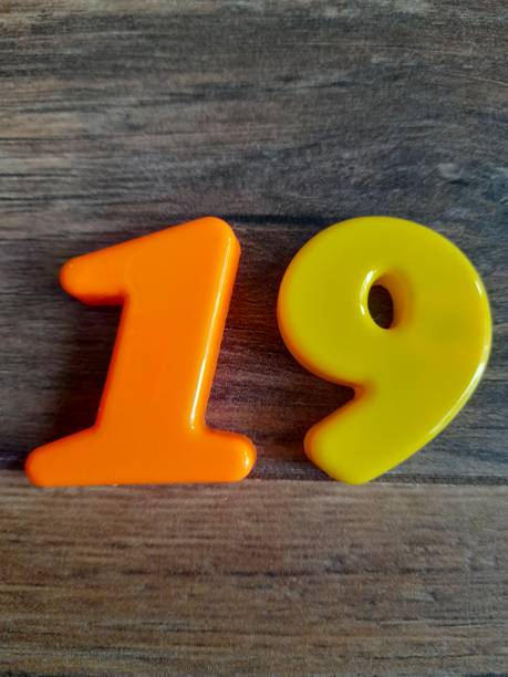 istock 19 number with wooden background 2150460100