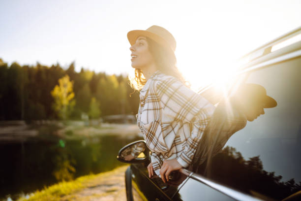 istock Relaxed woman leaning out car window during summer trip. 2150460295