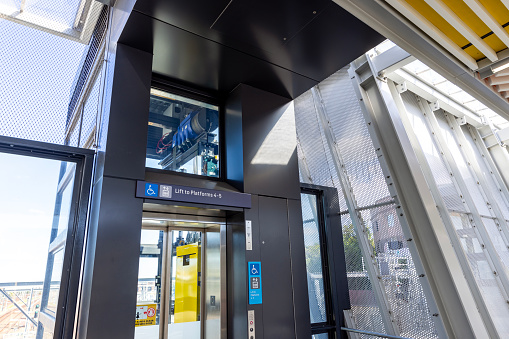 Train station modern elevator in pedestrian overpass footbridge, Redfern NSW Australia, full frame horizontal composition
