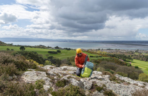 istock Hiker man in mountain top, searching for items from his backpack. 2150464320