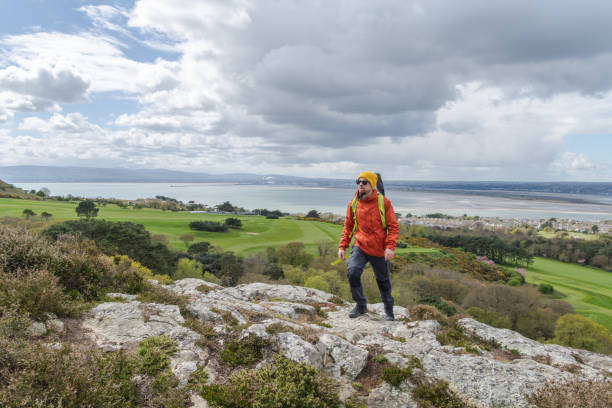 istock Hiker man with backpack reaching the mountain top. 2150464323