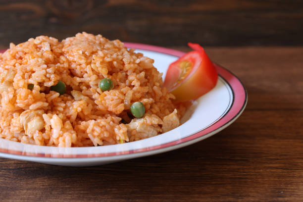Chicken rice on the dish isolated on a wooden table.
