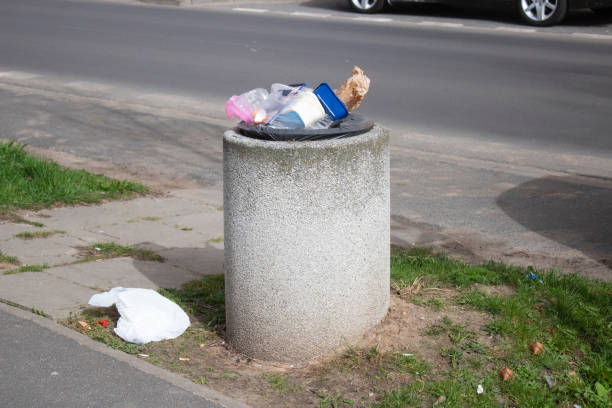 istock Public trash can on a city street filled with garbage 2150467419