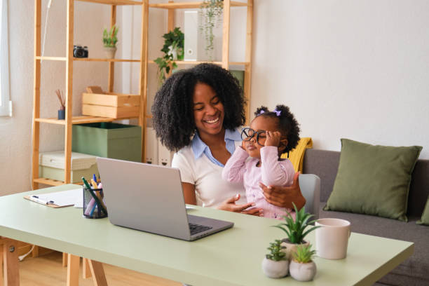 istock Mother working while holding her child who is playing with a glasses. 2150472623