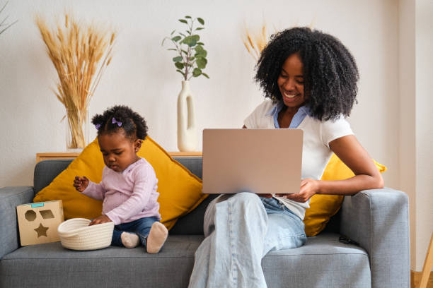 istock A woman is working on her laptop while her daughter plays with a toy. 2150472690