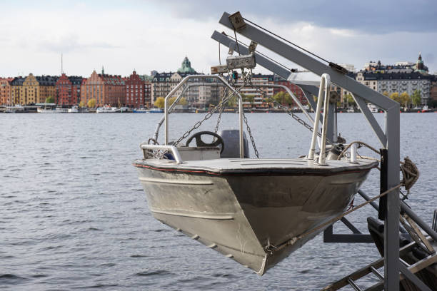 Quaint old-fashioned boats moored in a peaceful harbor next to charming ochre buildings. The surrounding greenery captures a balanced blend of architectural and natural beauty, evoking tranquility and maritime heritage.
