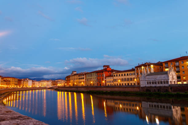 Panoramic view of the old town of Pisa and the Arno river at twilight, Italy. Night cityscape