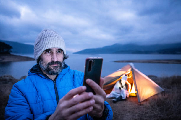 istock Online chat while camping in nature at lakeshore. 2150480421