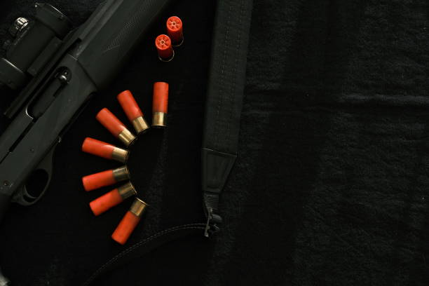 Weapon on black cloth: rifle, shells,top view. Top view of rifle, shells on black cloth background.