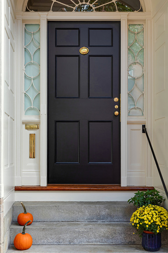 A black door in New England, embodying classic charm and a warm, welcoming presence.