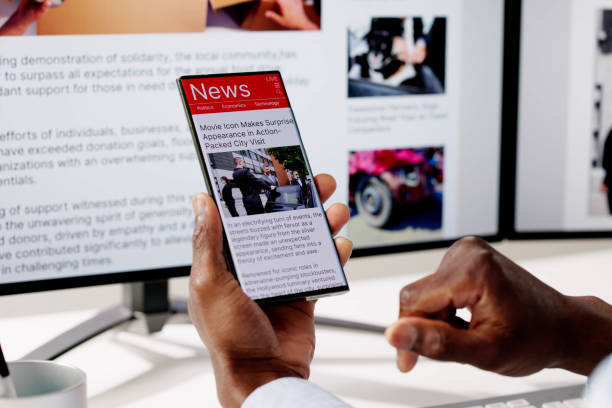 istock Watching Online News Article On Mobile Phone And Laptop 2150486324