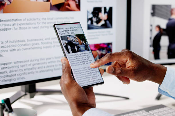 istock Watching Online News Article On Mobile Phone And Laptop 2150486325