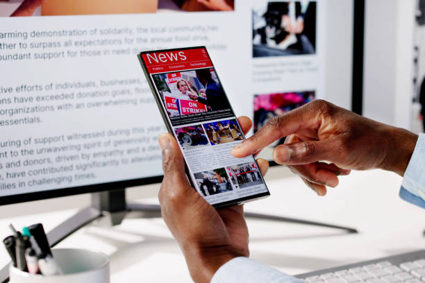 istock Watching Online News Article On Mobile Phone And Laptop 2150486338