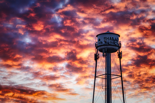 Shamrock, Texas, USA - December 26, 2023: The winter sun sets on Route 66 behind the water tower.