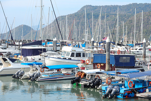 Langkawi, Malaysia March 11, 2024: Scenery of boats and sailboats anchoring at harbor in Langkawi Malaysia.