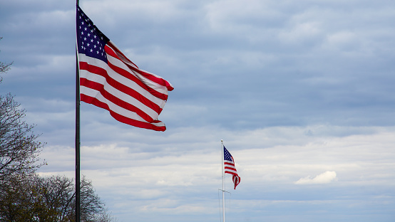 Two American flags blowing in the wind