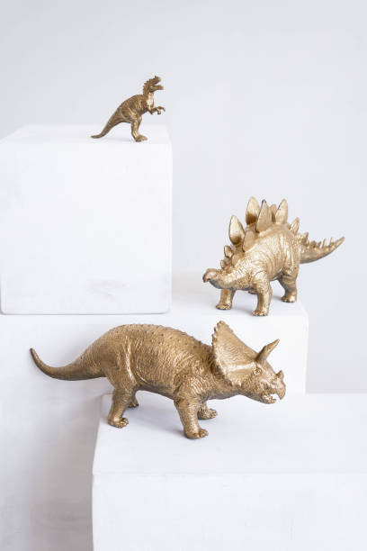 Golden dinosaur figurines on a white background.