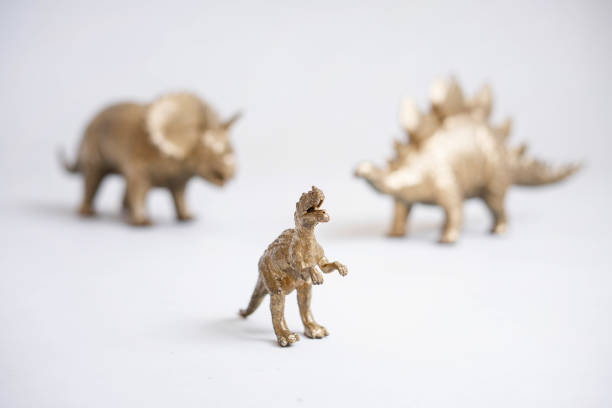 istock Golden dinosaur figurines on a white background. 2150493334