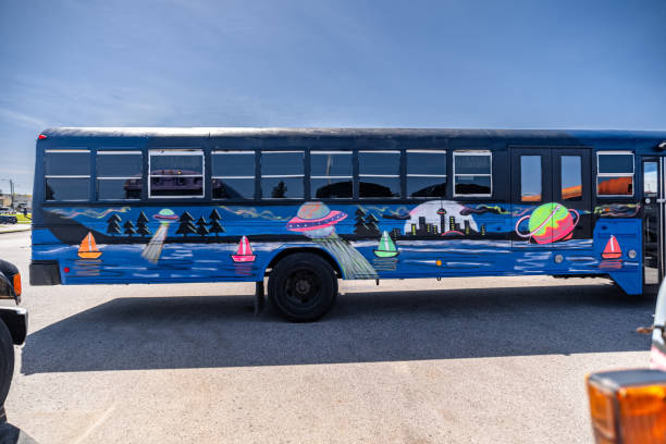 Party bus with painted mural on the exterior. Retired school bus converted in to party bus, decorated with unique art mural on it's side. Exterior of public parking lot in Toronto, Canada.