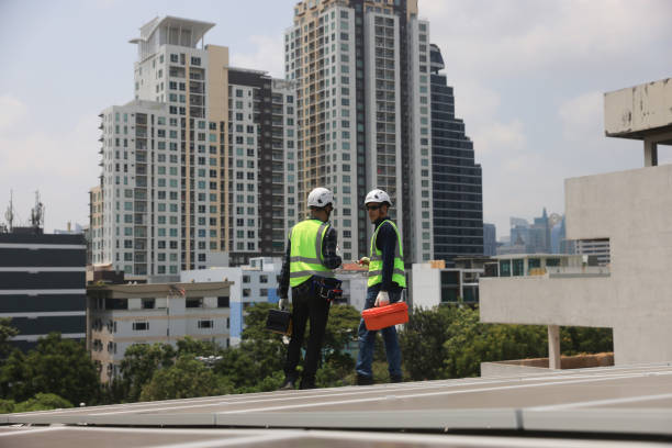 Two male Solar engineers working on the rooftop solar panel installations for quality assurance and maintenance.