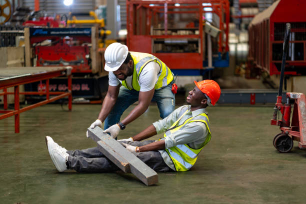 istock African American factory worker having accident while working in manufacturing site while his colleague is helping  for safety workplace and emergency 2150499623