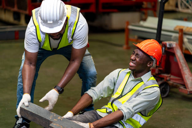istock African American factory worker having an accident while working in manufacturing site while his colleague is helping  for safety workplace and emergency 2150499627