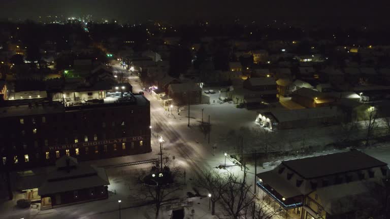 Aerial footage through the small town of Lititz PA on a snowy winter evening, looking north.