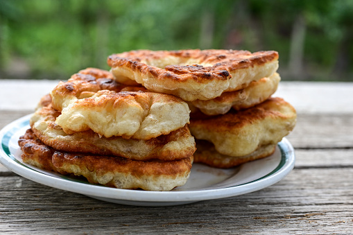 Traditional Bulgarian homemade donut breakfast.Mekitsa or Mekica,  on wooden  background. Made of kneaded dough that is deep fried