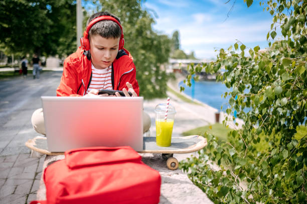 istock Teenager using laptop outdoors in the city 2150506565