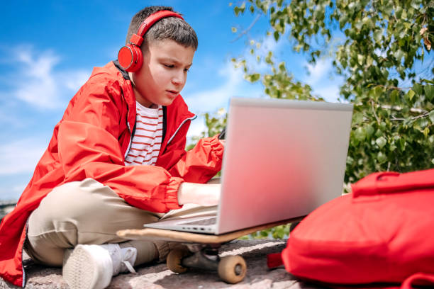 istock Teenager using laptop outdoors in the city 2150506567