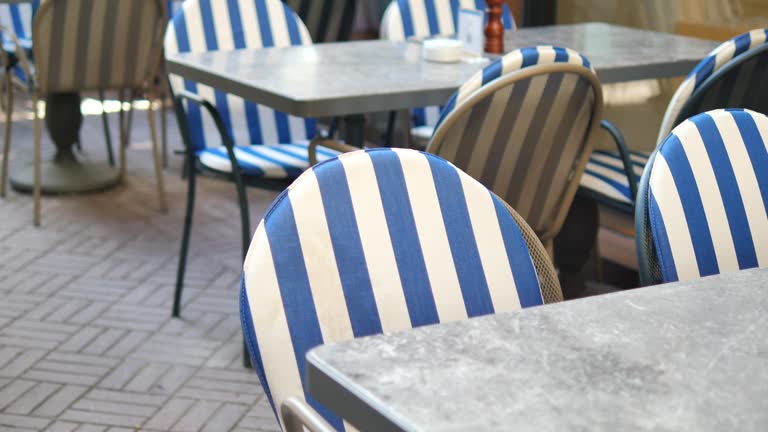 A city restaurant with blue and white striped outdoor furniture