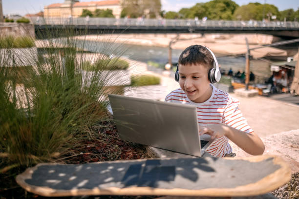 istock Teenager using laptop outdoors in the city 2150506729